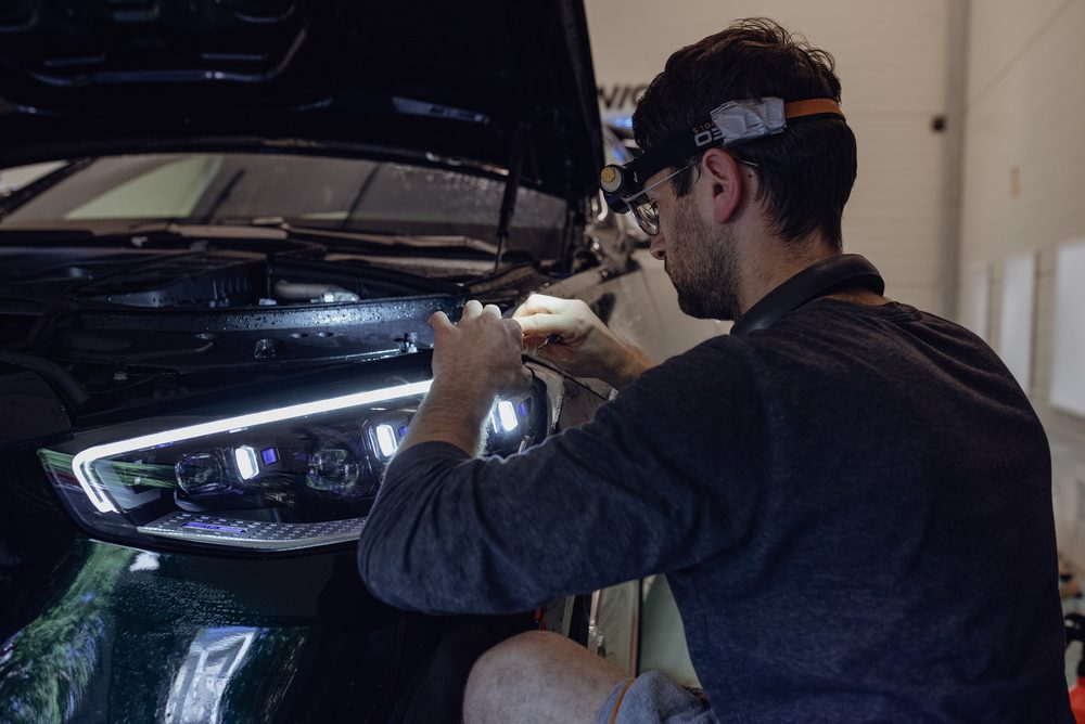 Detailer pracujący przy reflektorze auta premium