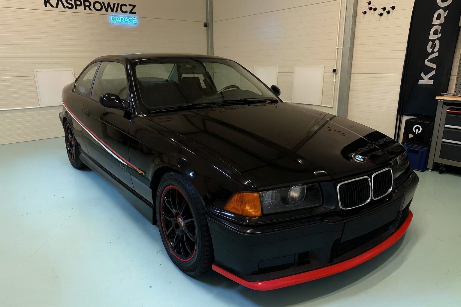 BMW E36 w czarnej stylizacji z czerwoną dokładką przedniego zderzaka