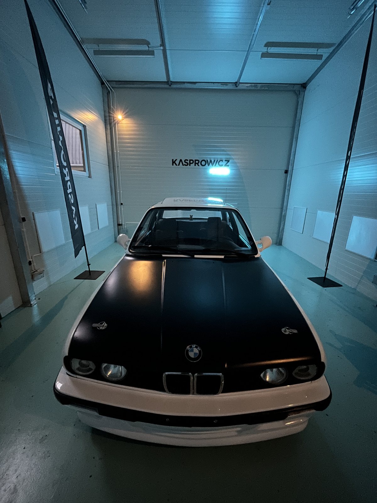 Białe BMW E36 z czarną folią na masce w studiu
